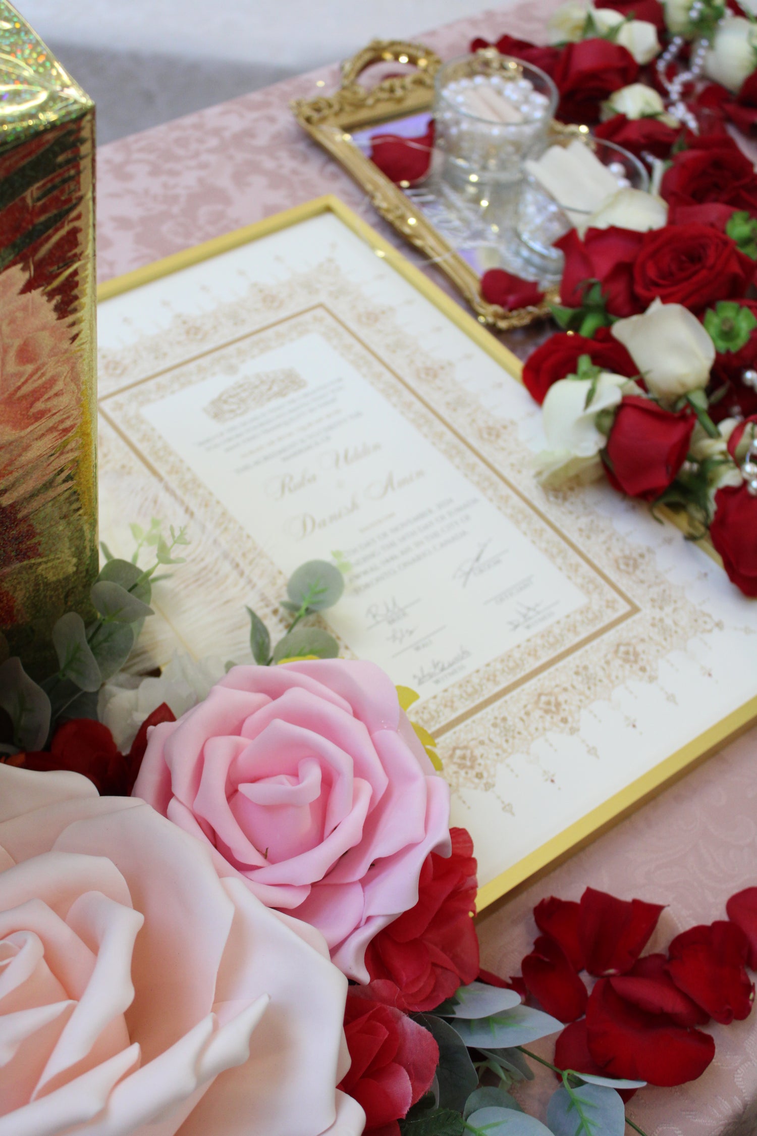 A portrait image of a Nikah Certificate next to wedding decor. 